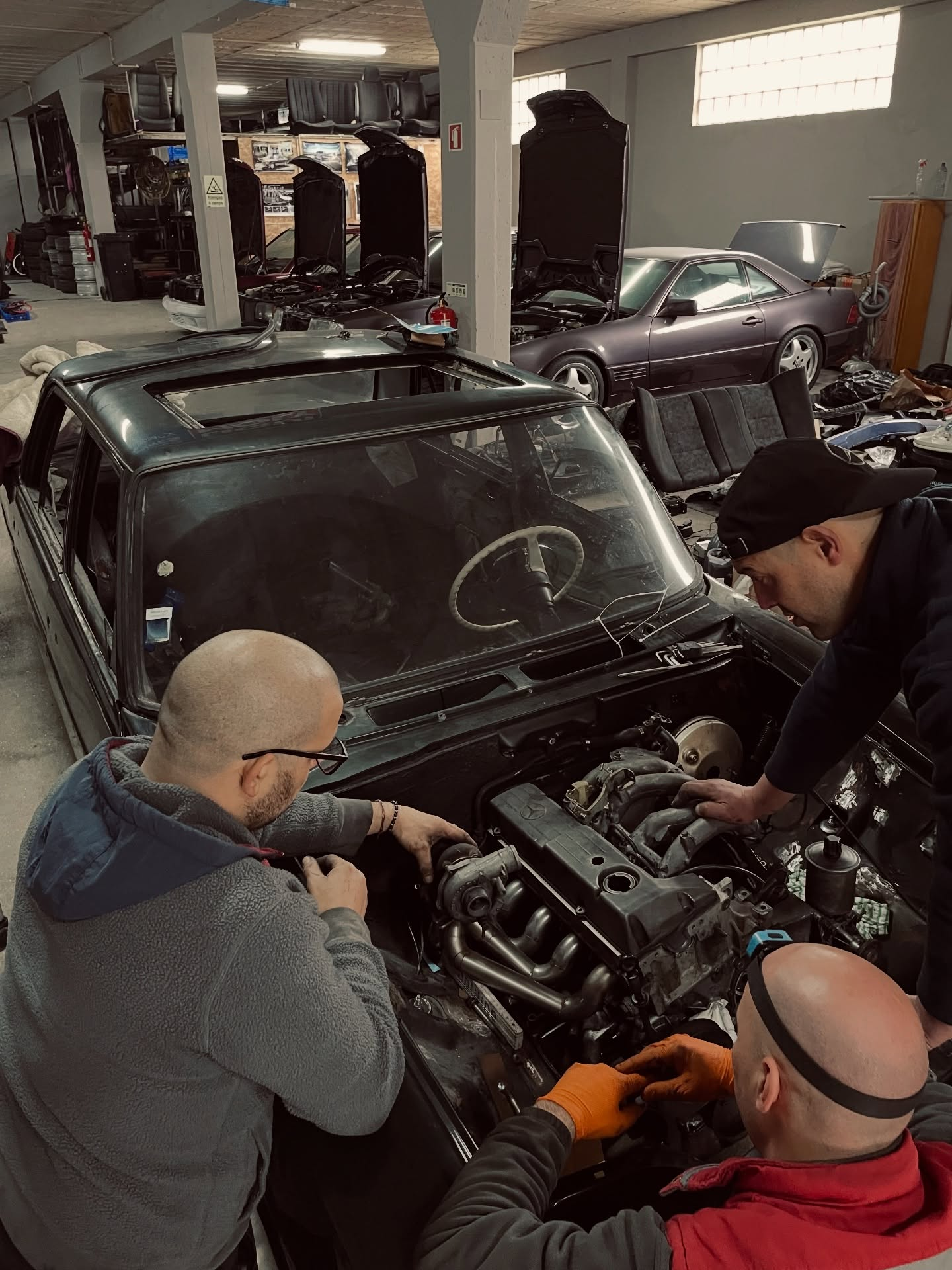 Equipa a trabalhar no motor de um Mercedes-Benz na oficina